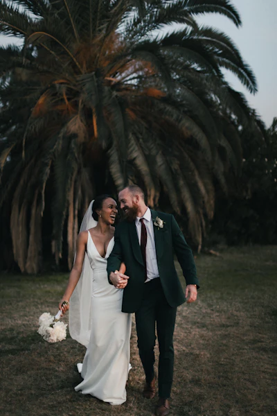 Couple in sleek wedding attire photographed in the city at twilight